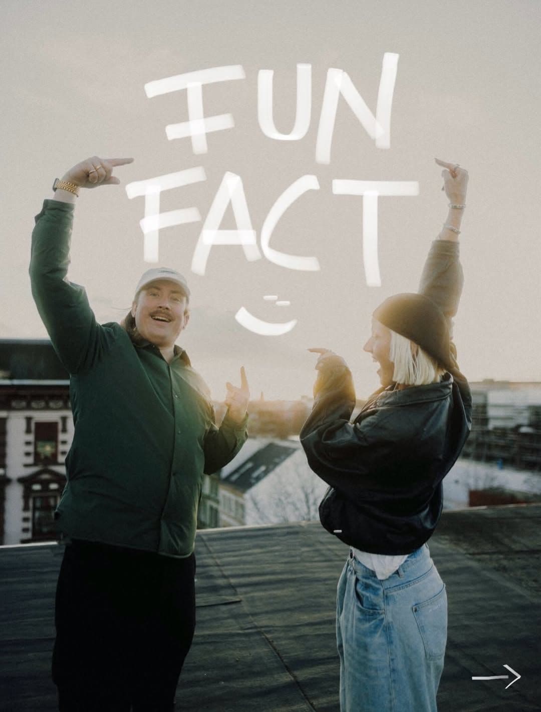 Leonie Sun und Robert Lindemann stehen auf einem Dach und zeigen auf einen "Fun Fact" Schriftzug über ihren Köpfen