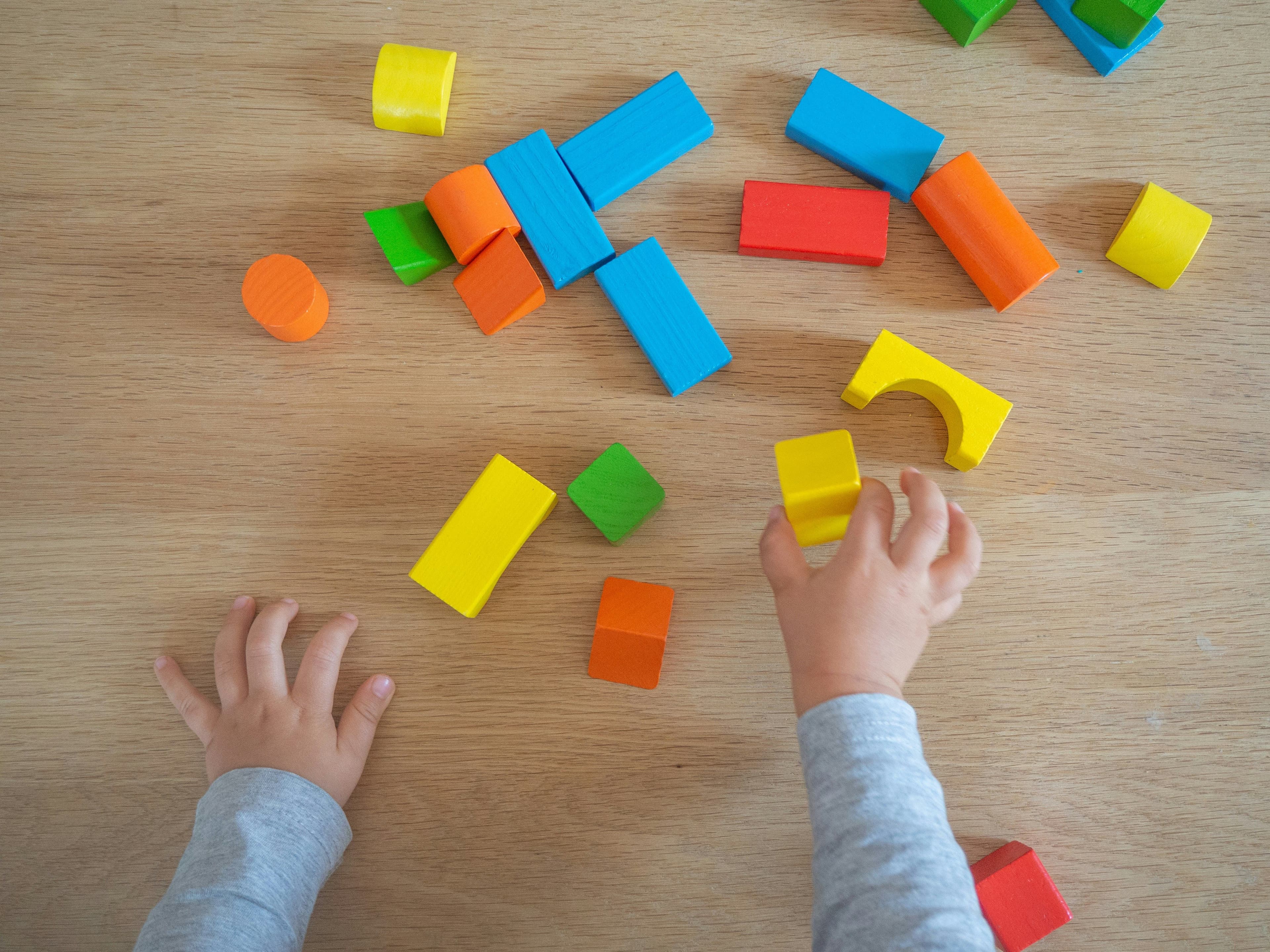 Kinderhände spielen mit Bauklötzen