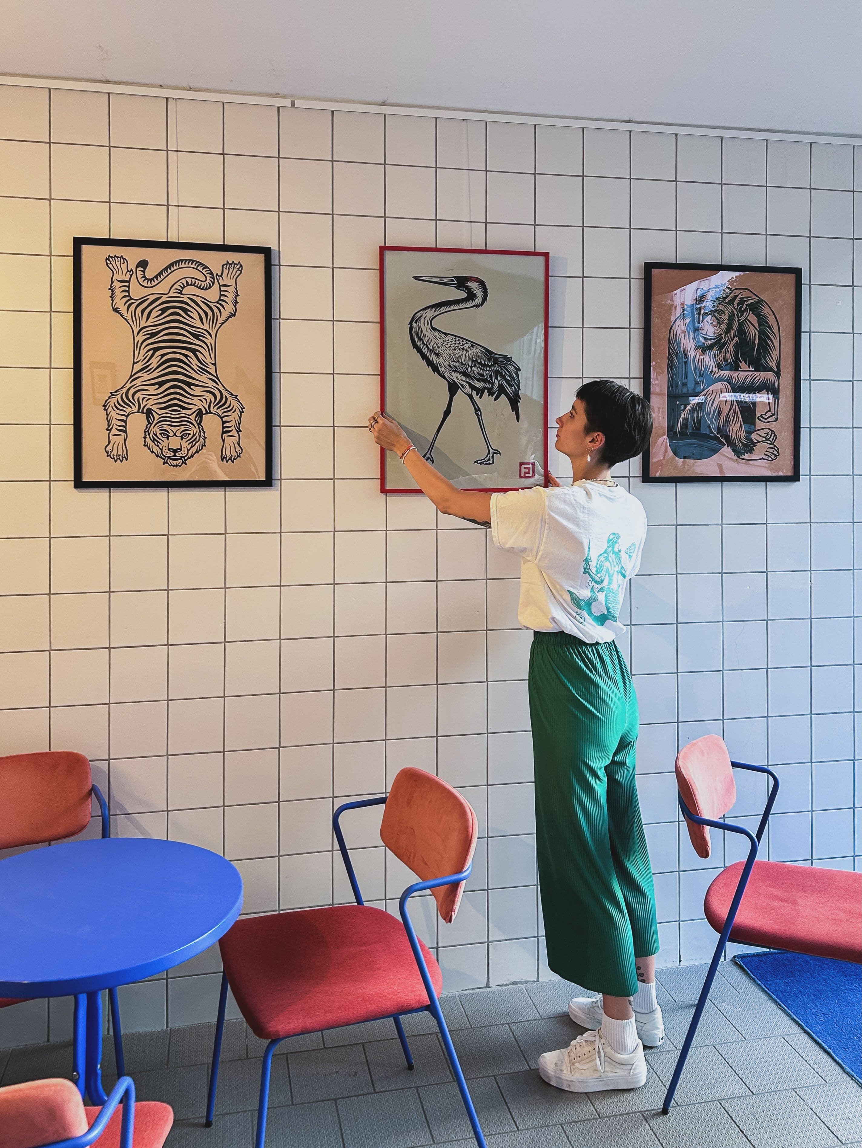 Juliana Fischer hängt Bilder in einem Café auf