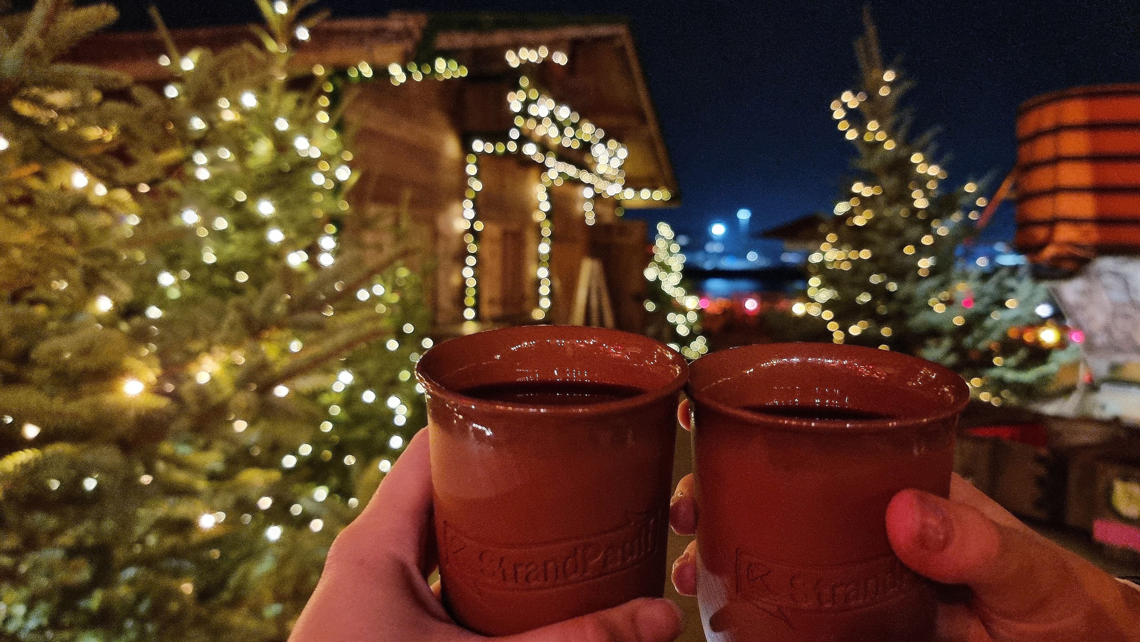Becher mit Glühwein stoßen an