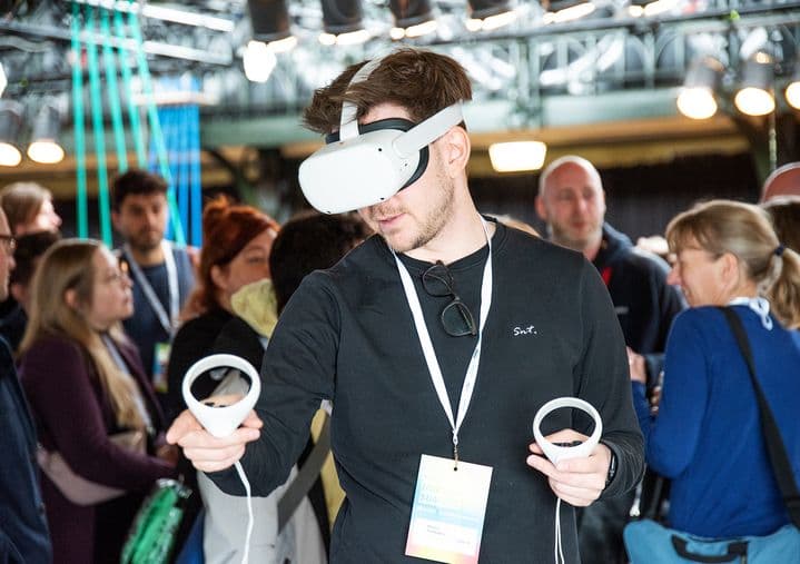 Eine Person mit VR-Brille probiert eine neuartige Technologie aus.