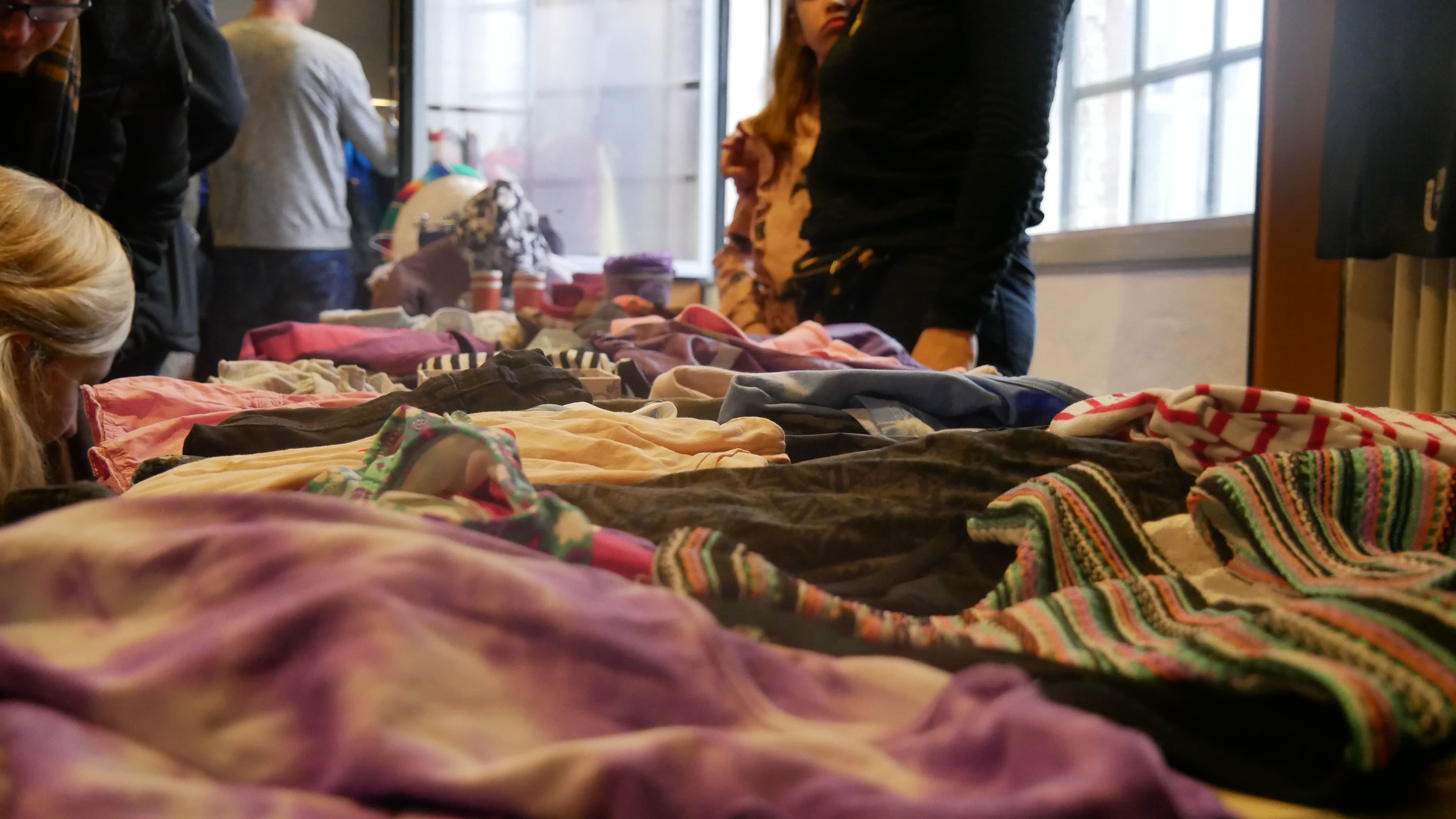 Verschiedene Kleidungsstücke liegen auf einem Verkaufsstand