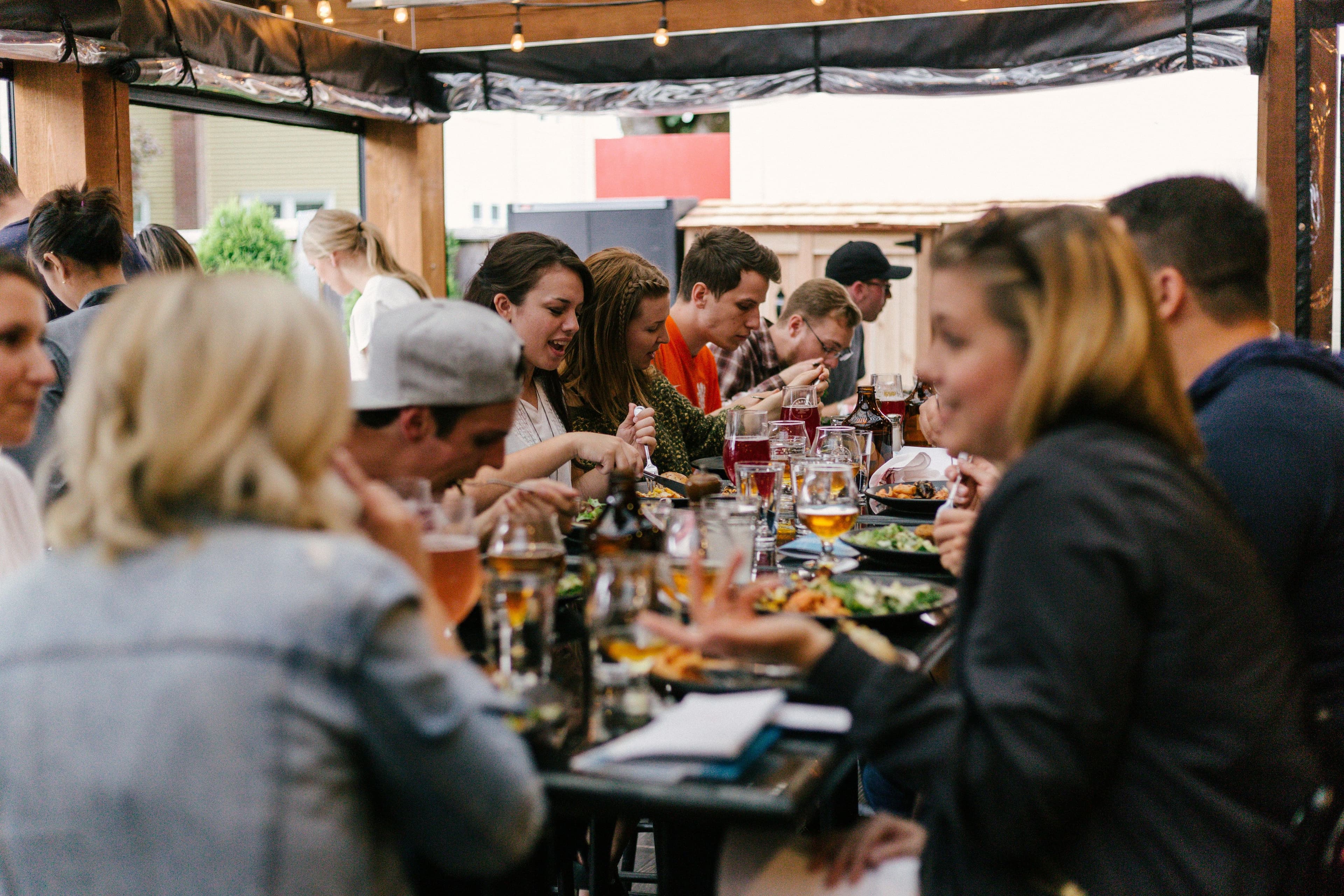 Menschen sitzen gemeinsam an einem Tisch und essen