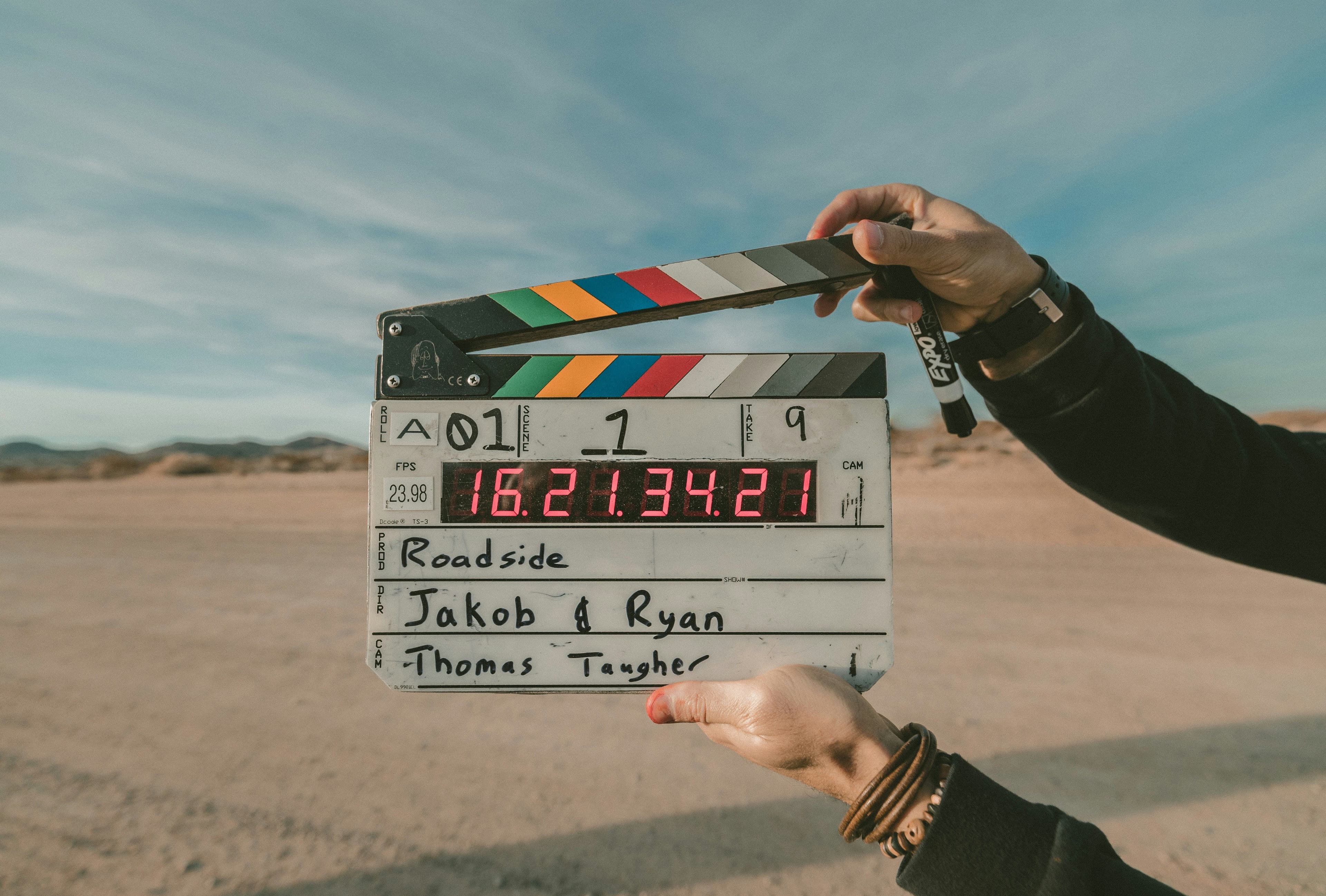 Eine Filmklappe wird von zwei Händen gehalten