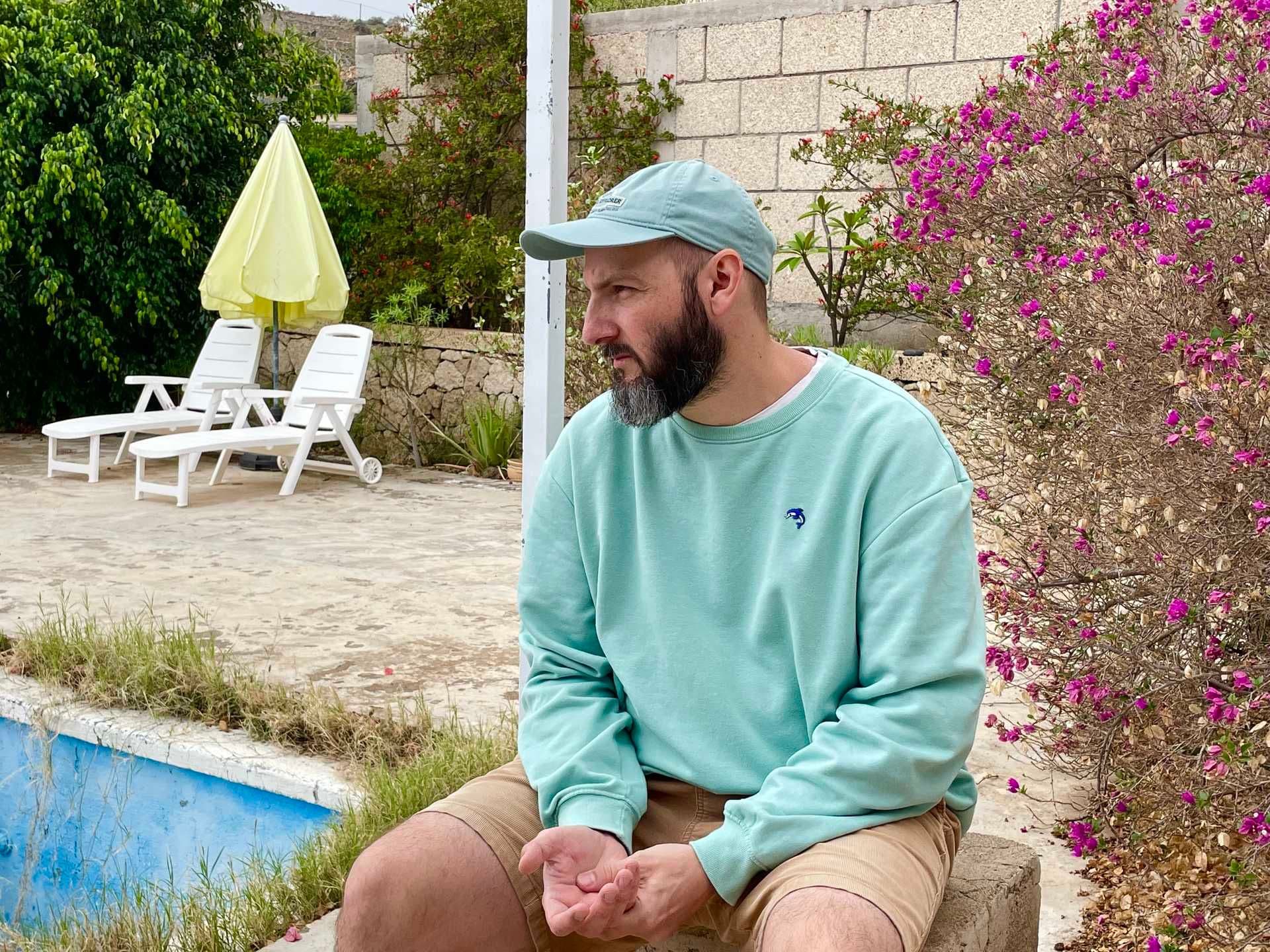 Der DJ hainaland sitzt draußen vor einem Pool