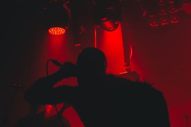 Die schwarze Silhouette eines Mannes, der in ein Mikrofon schreit