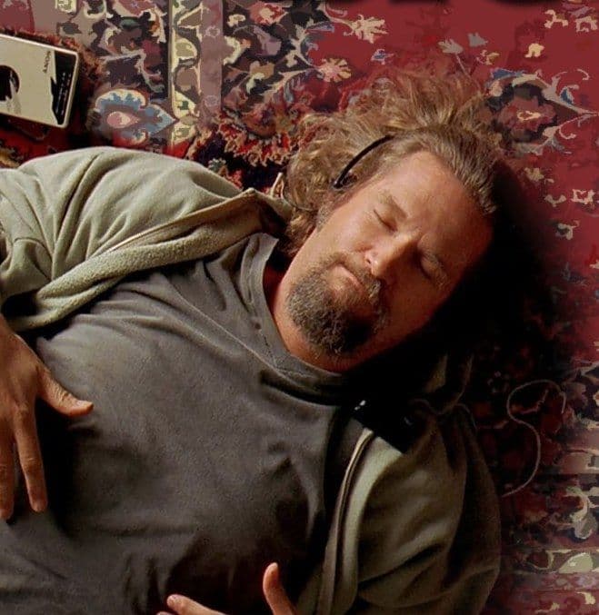 Jeff Bridges liegt mit Kopfhörern und geschlossenen Augen auf einem Teppich.