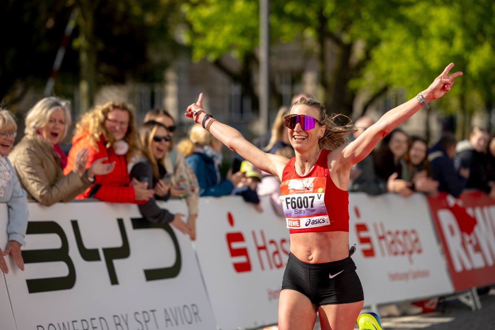 Eine Frau läuft den Haspa Marathon und wird von Menschen angefeuert