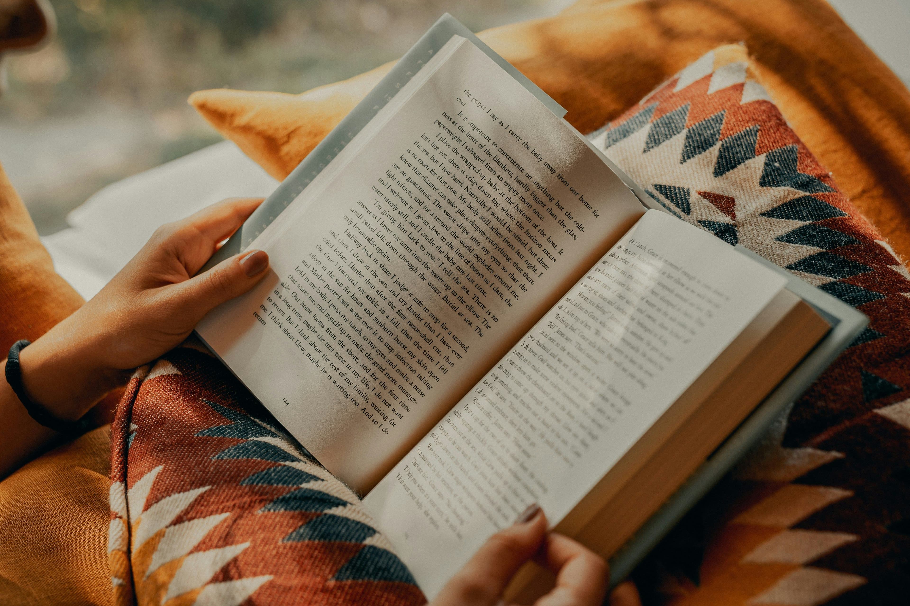 Eine Person hält ein aufgeschlagenes Buch in den Händen