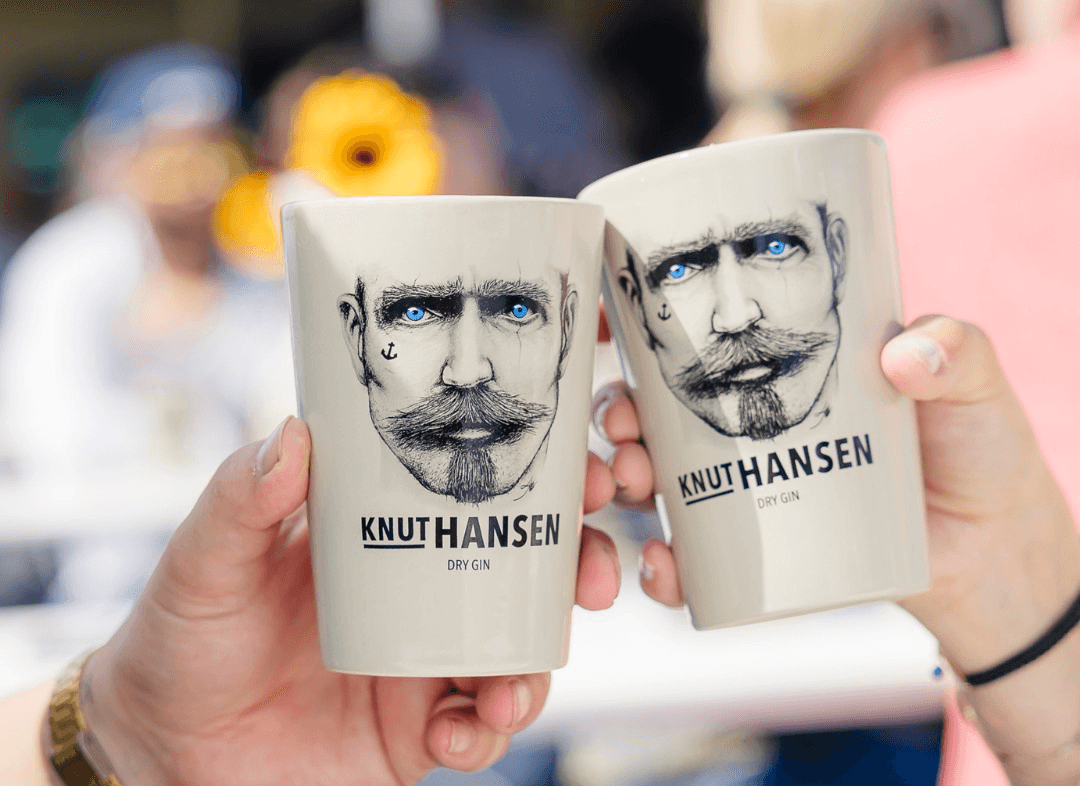 Zwei Becher mit der Aufschrift KNUT HANSEN stoßen an