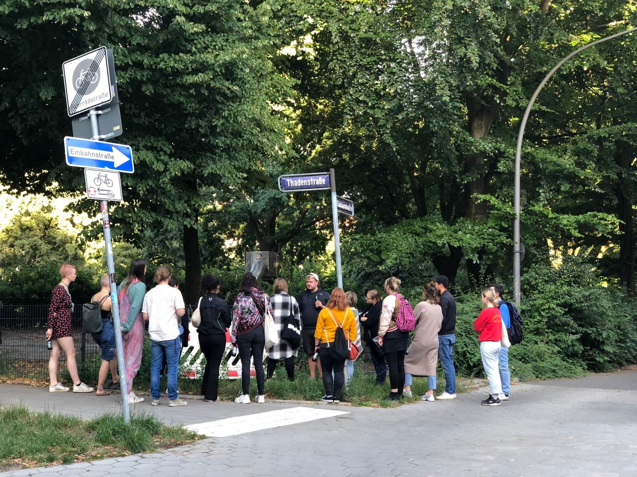 Eine Gruppe Menschen steht an einem Straßenrand
