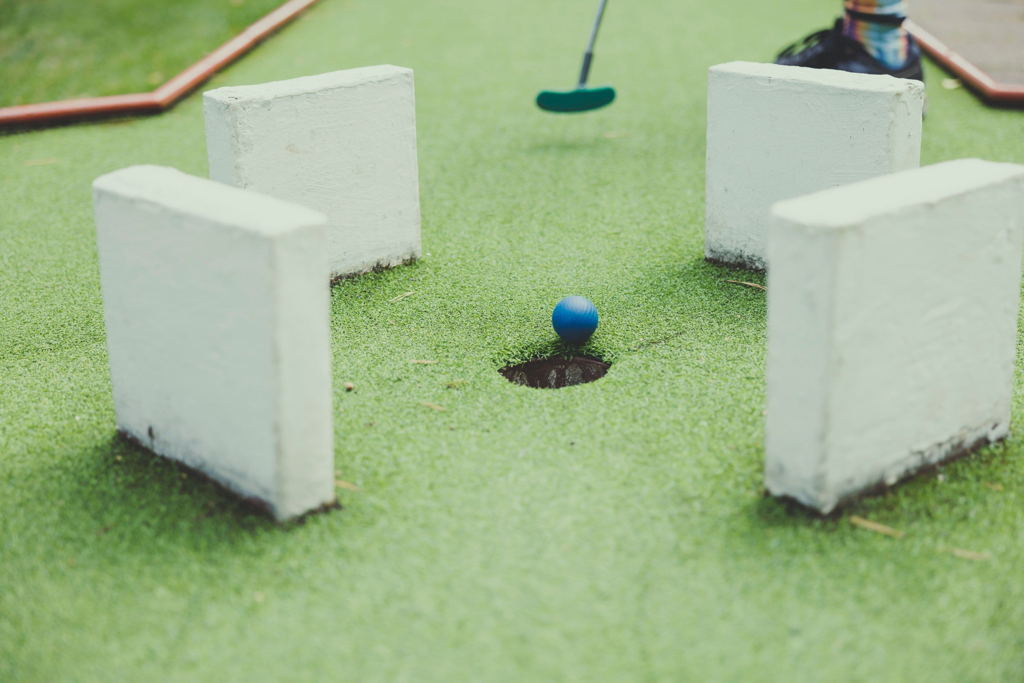 Minigolf-Ball mit Schläger und Bahn