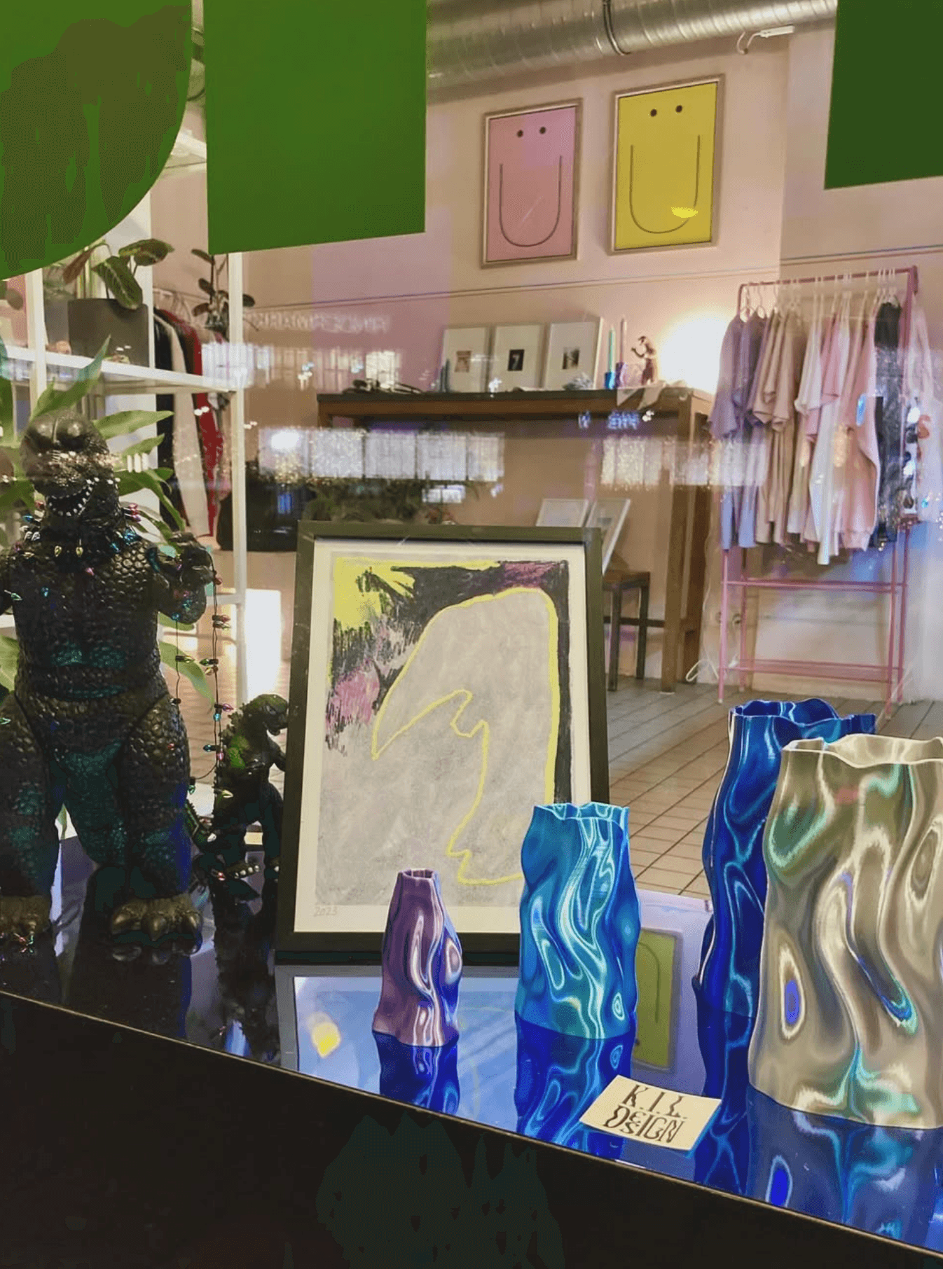 Schaufenstereinsicht des POP POP pop up shops mit bunten Vasen, Bildern und Kleidung.
