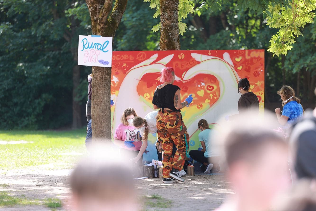 Personen besprühen eine Wand