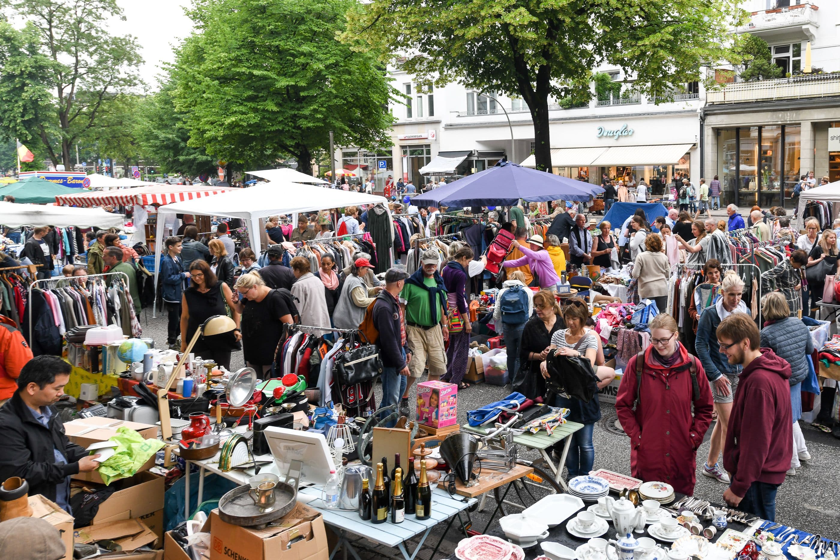 Menschen tummeln sich bei einem Flohmarkt Stand
