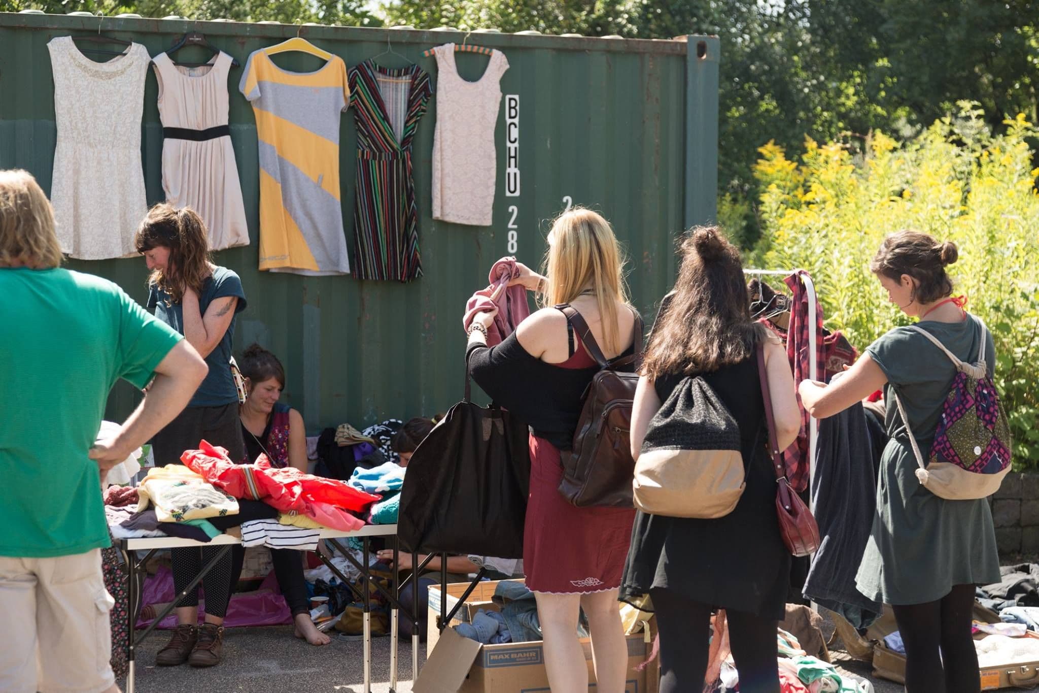 Menschen stöbern an Flohmarktständen.