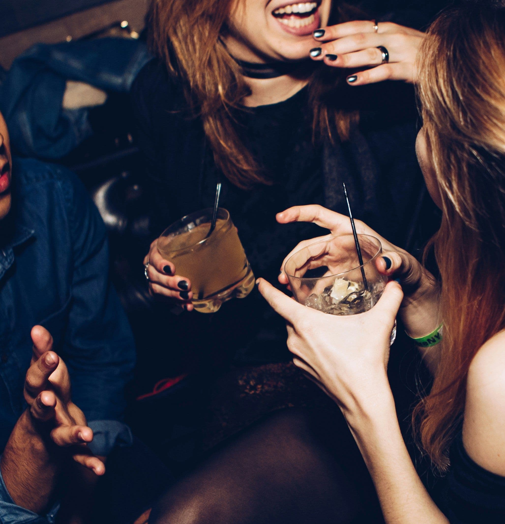 Zwei Frauen mit Drinks in der Hand unterhalten sich