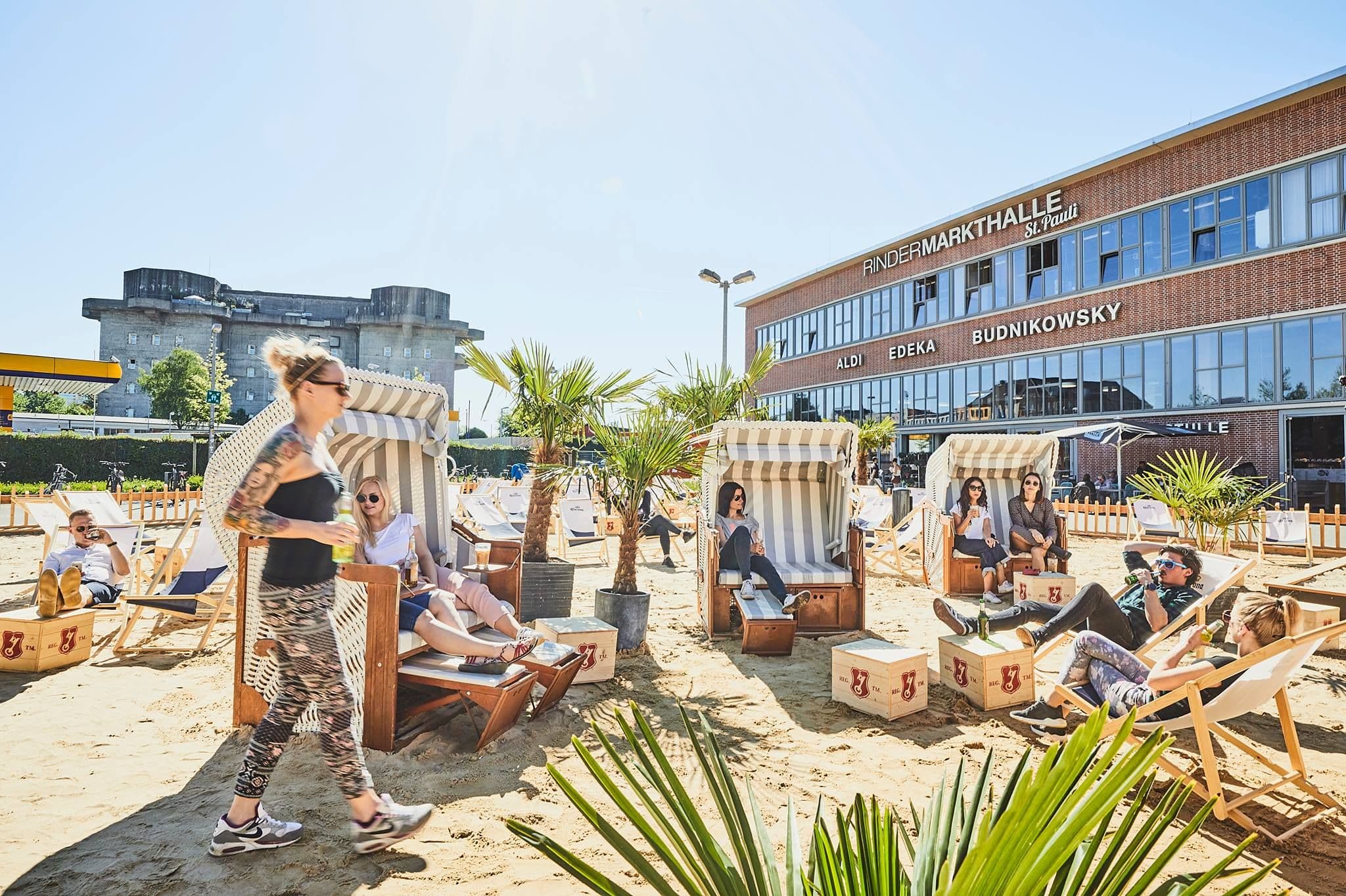 Personen sitzen in Strandkörben am Karo Beach vor der Rindermarkthalle.