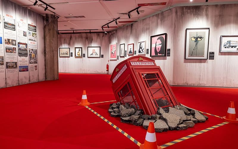 Kunstwerk von Banksy, Telefonzelle versinkt im Boden