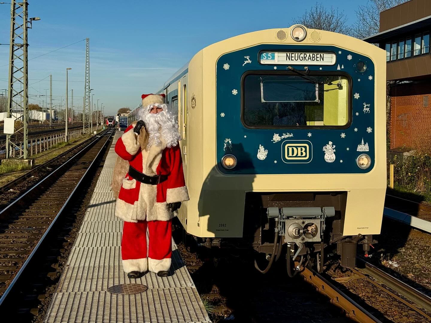 Ein Weihnachtsmann steht neben einer historischen S-Bahn