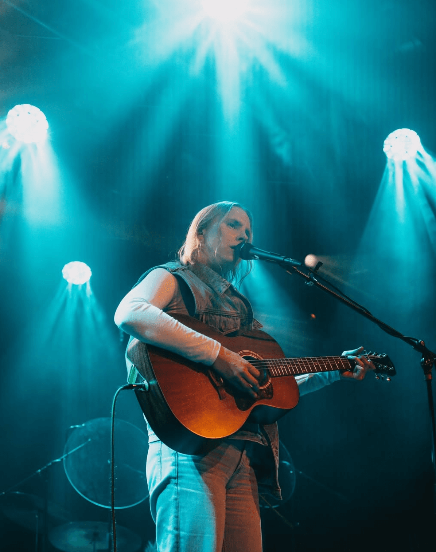 Die Musikerin Willow Parlo steht mit Gitarre und Mikrofon auf der Bühne