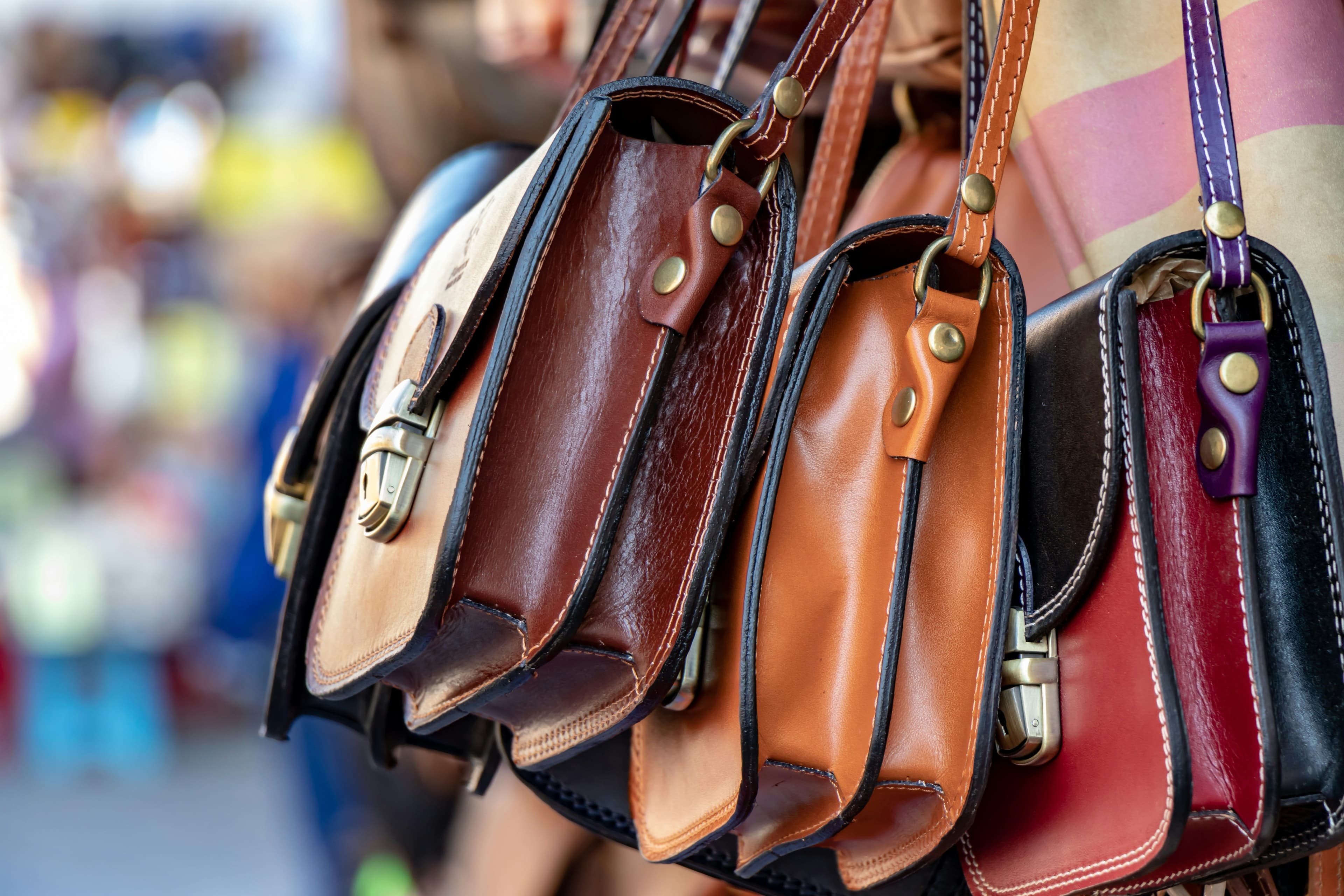 Drei Handtaschen aus Leder hängen an einem Ständer