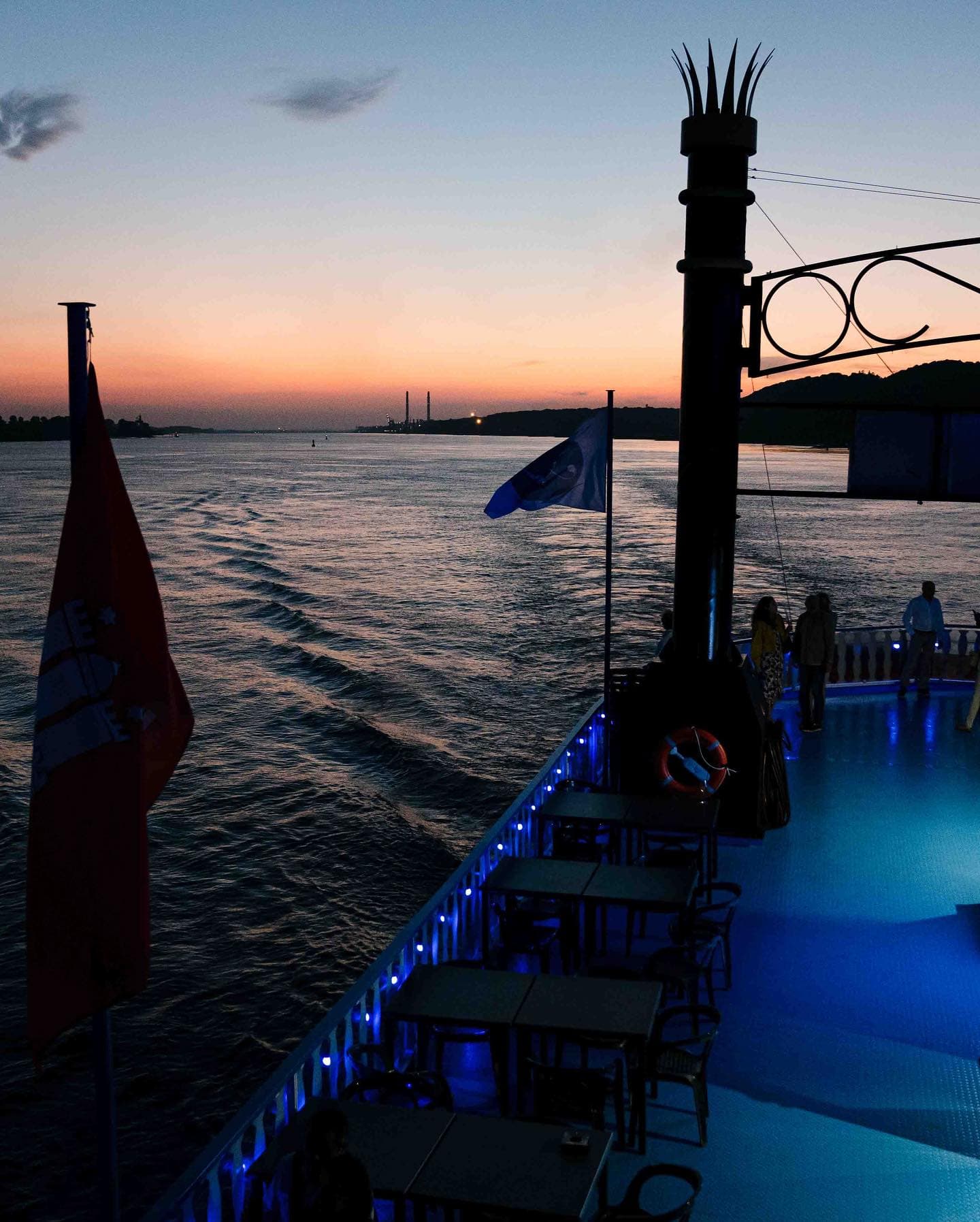 Ein blau ausgeleuchtetes Schiff in der Dämmerung auf der Elbe