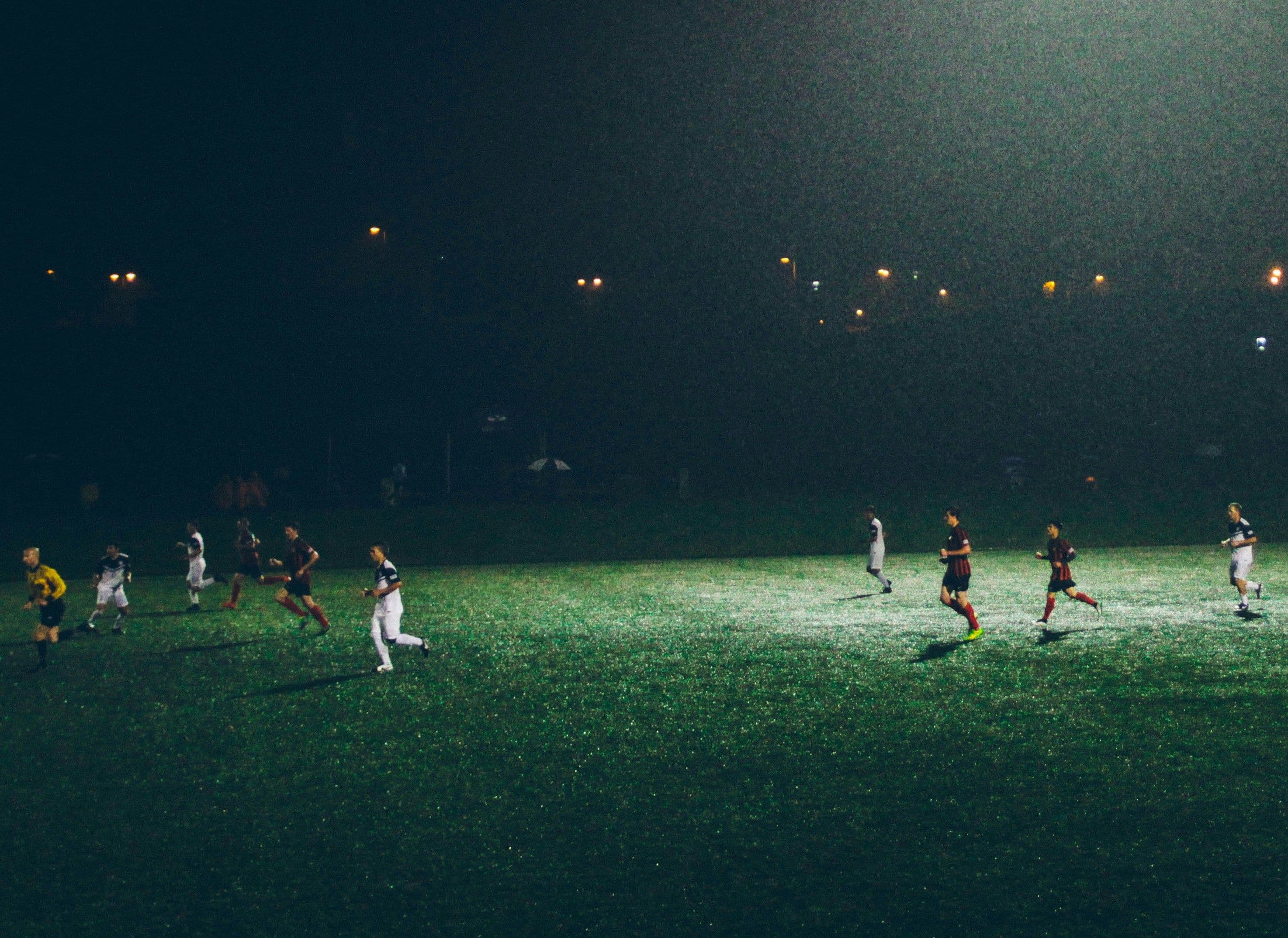 Fußballspieler laufen über Rasen