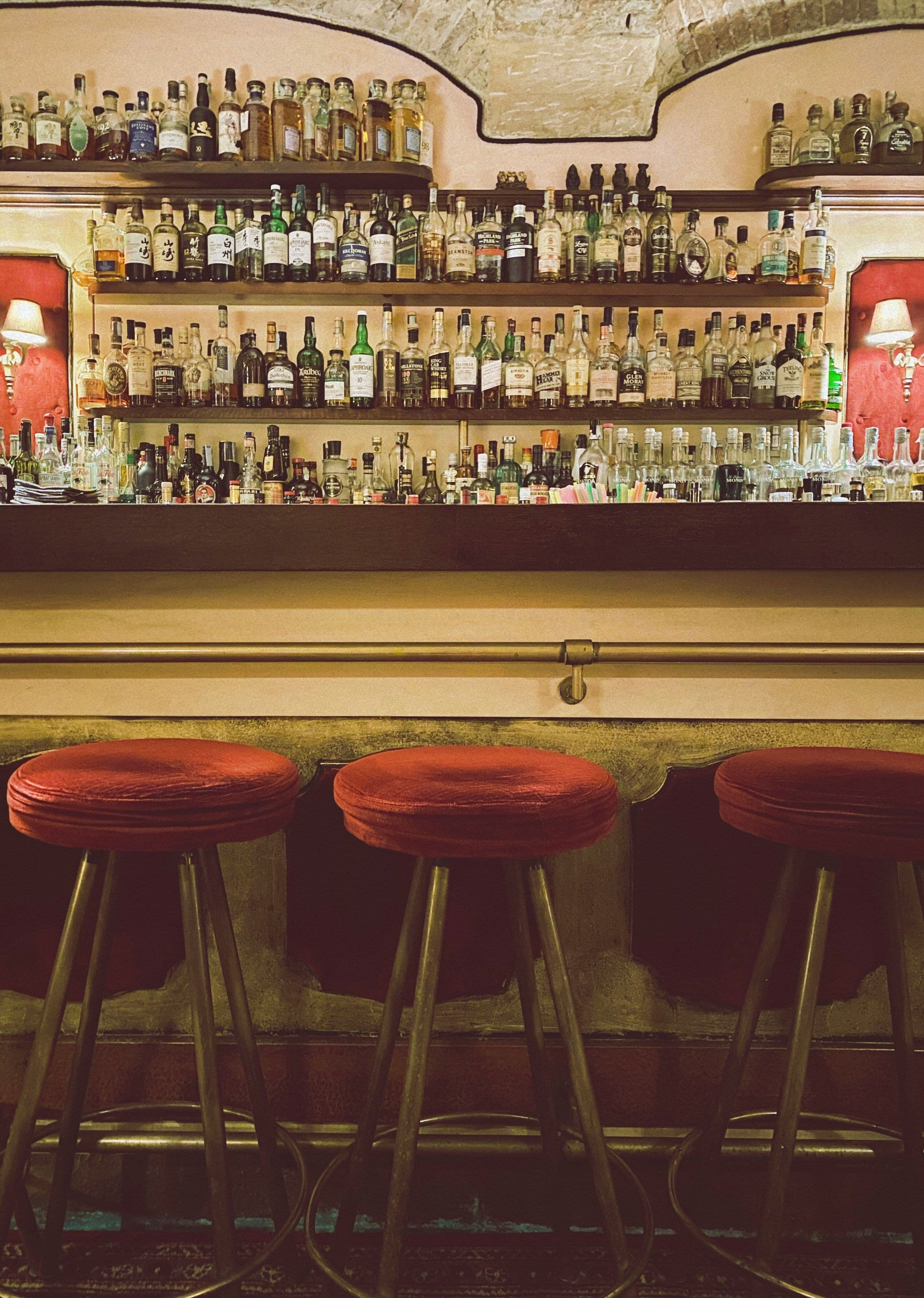 Eine Bar mit drei roten Barstühlen