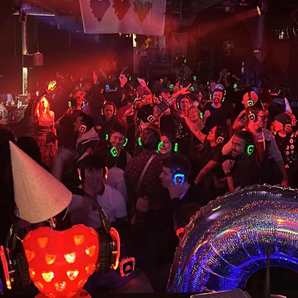 Leute tanzen mit leuchtenden Kopfhörern auf einer Party