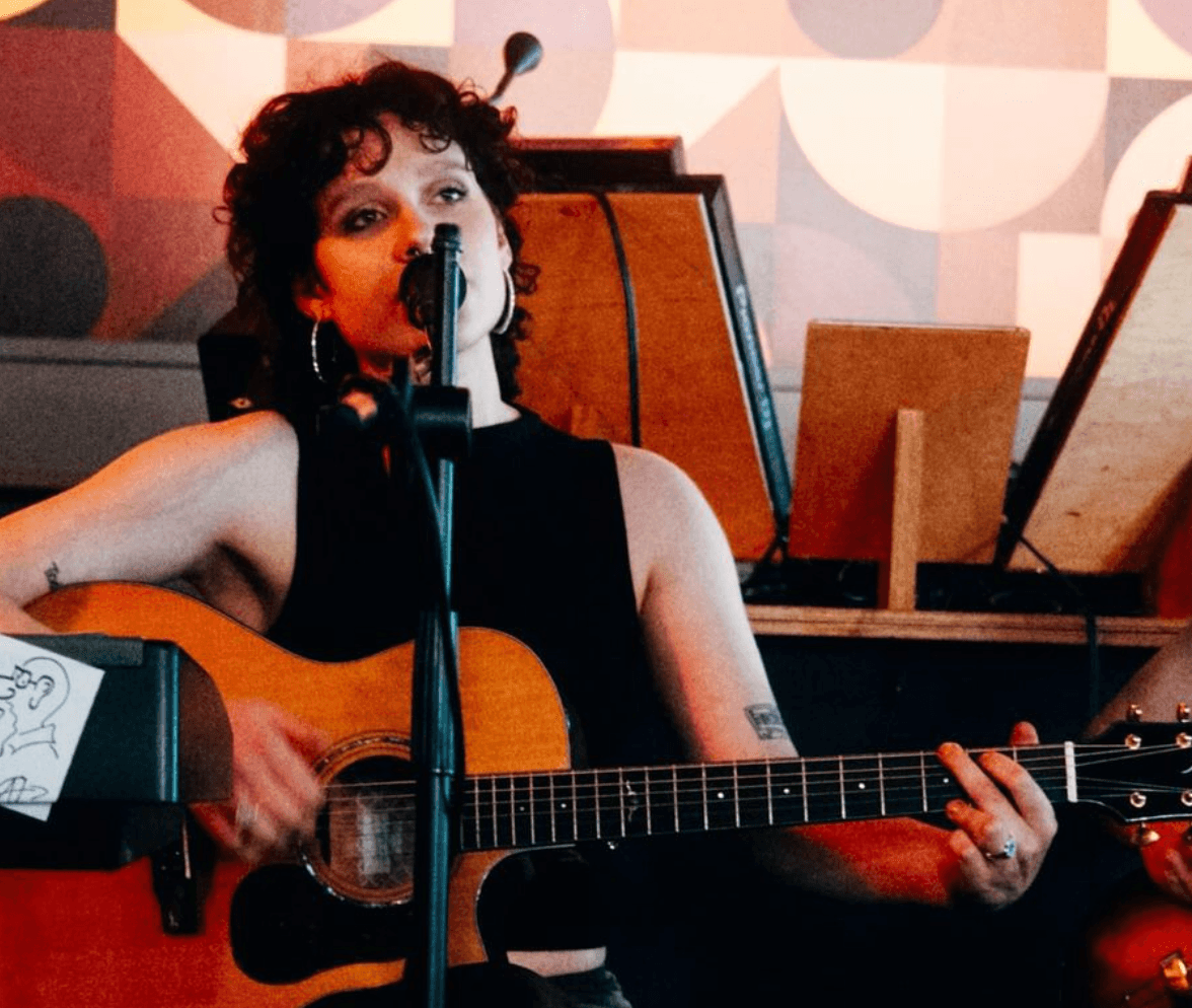 Svelet singt mit Mikrofon und Gitarre